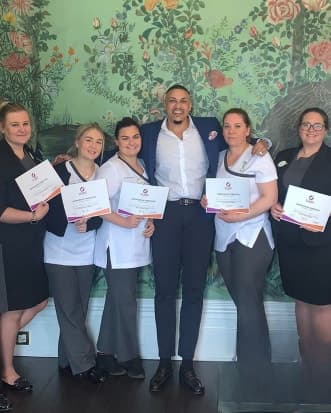 Kris Trinity with a training group holding certificates of completion